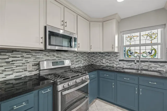 a kitchen with granite countertop a sink and a white cabinets