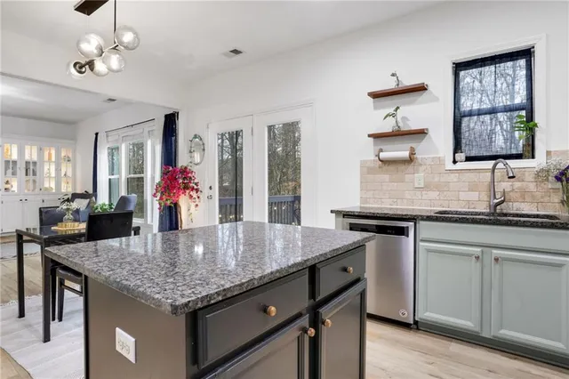 a kitchen with granite countertop kitchen island stainless steel appliances a sink and stove
