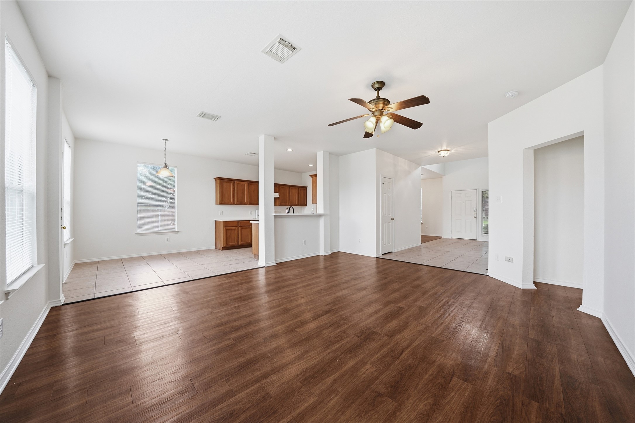 118 Invierno Street Kyle, TX 78640 - Photo 36 of 37 An open floor plan seamlessly connects the naturally illuminated living space with the adjacent kitchen.