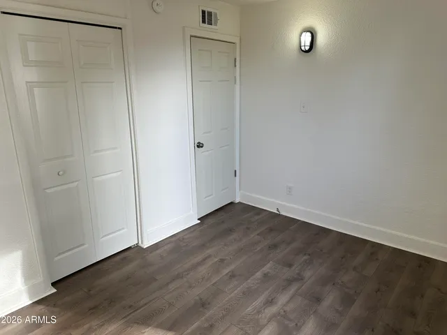 an empty room with wooden floor and closet