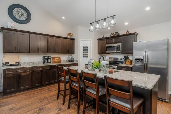 a kitchen with a table chairs microwave and cabinets