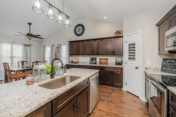 a kitchen with stainless steel appliances granite countertop a sink stove and refrigerator