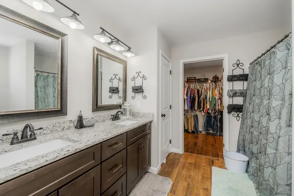 a bathroom with a granite countertop sink mirror and shower