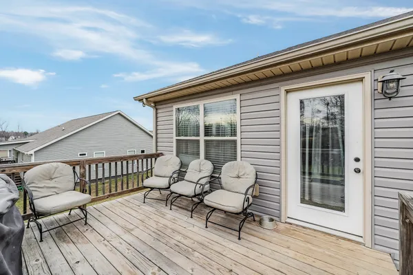 a balcony with wooden floor table and chairs