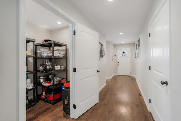 a view of a hallway with workspace and wooden floor