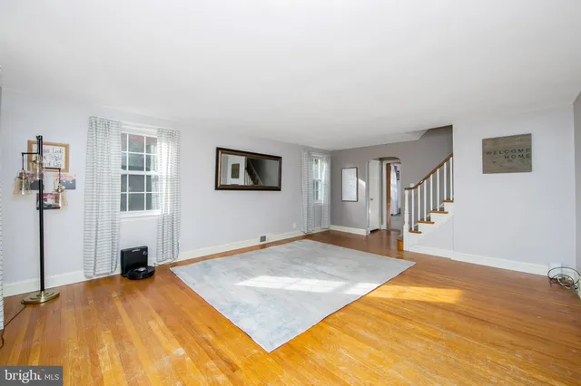 a view of a bedroom with wooden floor and a ceiling fan