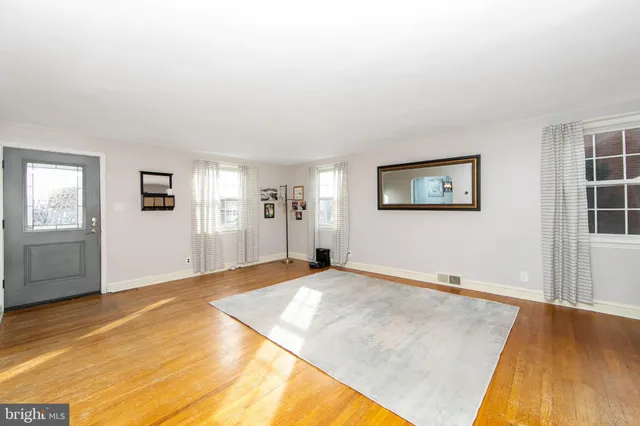 a view of empty room with wooden floor and stairs
