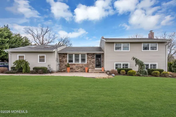 a front view of house with a garden and trees