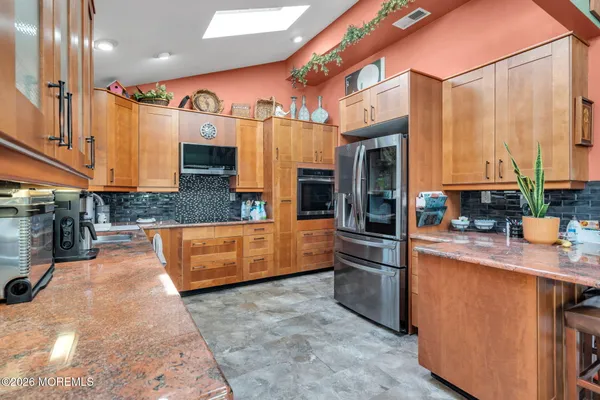 a kitchen with stainless steel appliances granite countertop a stove a sink and a microwave