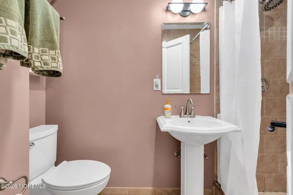 a view of an empty room with wooden floor and a ceiling fan