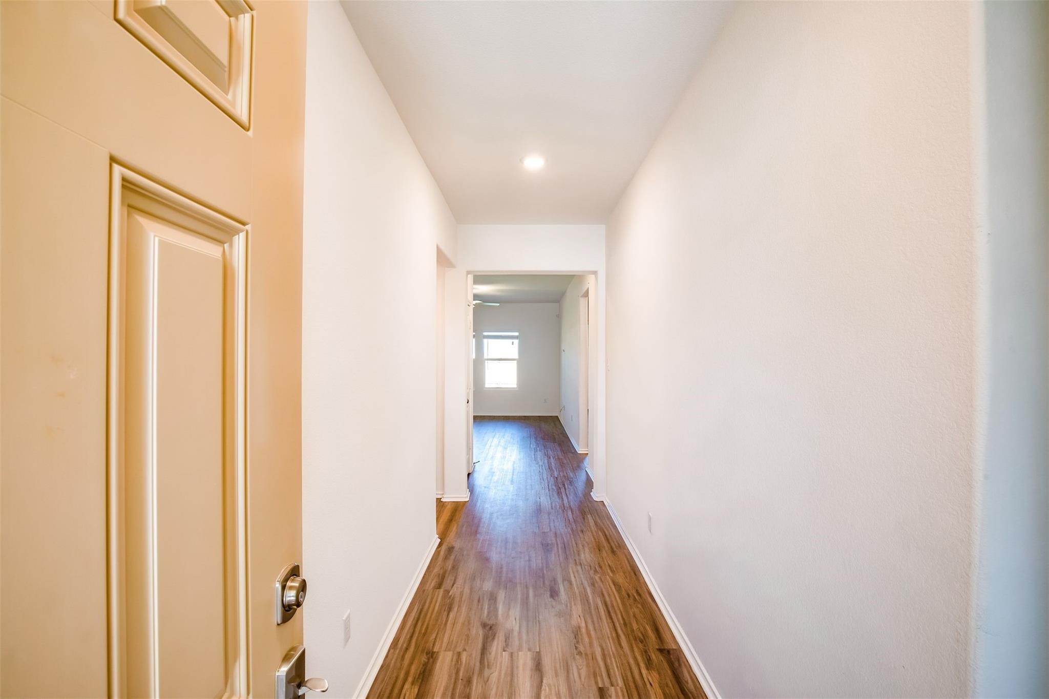 614 Milliner Loop Hutto, TX 78634 - Photo 25 of 25 A welcoming entryway with durable wood flooring leads to a brightly lit living area.