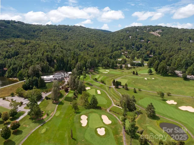 an aerial view of a residential houses with yard