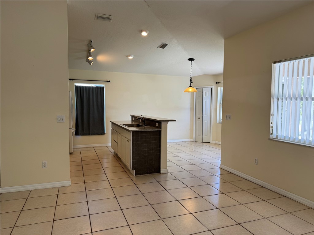 1489 Whitmore Street Sebastian, FL 32958 - Photo 3 of 24 an empty room & kitchen space with wooden floor