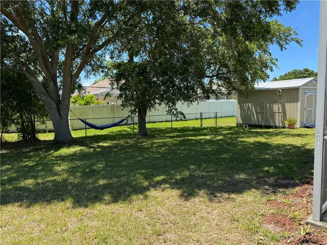 a view of a backyard with large trees