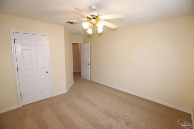 a view of an empty room with a chandelier fan