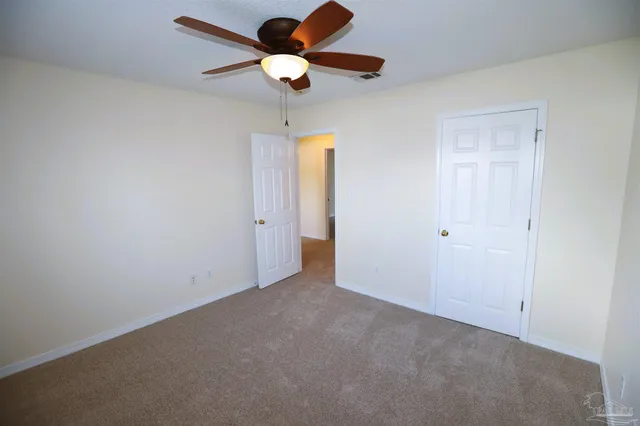 a view of an empty room and a ceiling fan