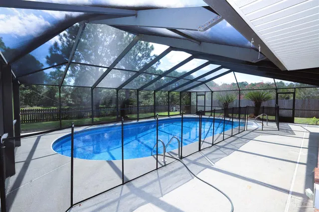 a view of a patio with a table and chairs under an umbrella with a small garden