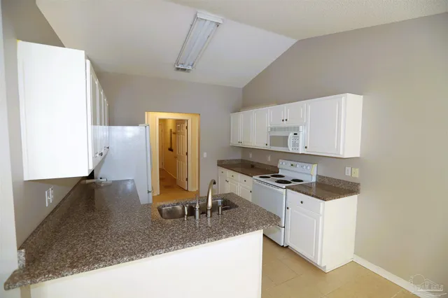 a kitchen with a sink a stove and cabinets