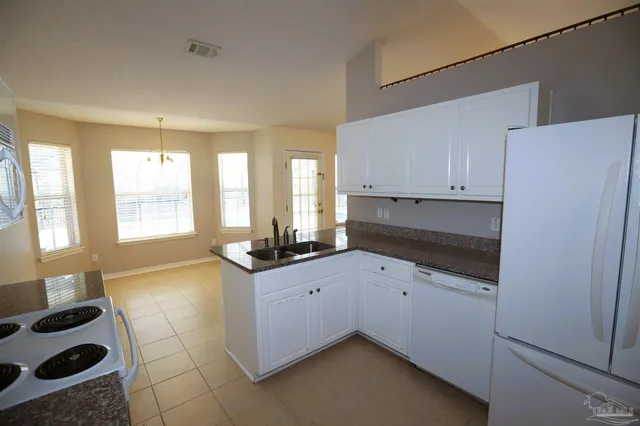 a kitchen with a sink a stove and cabinets