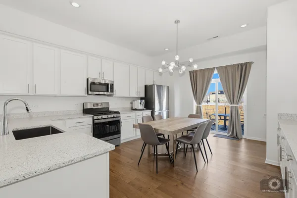 a kitchen that has a table chairs and wooden floor