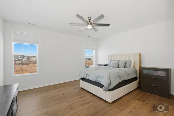 a spacious bedroom with a bed and a dresser