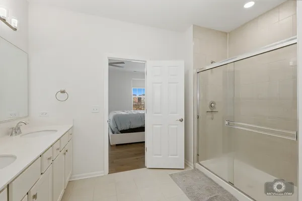 a en suite bathroom with a shower sink and mirror