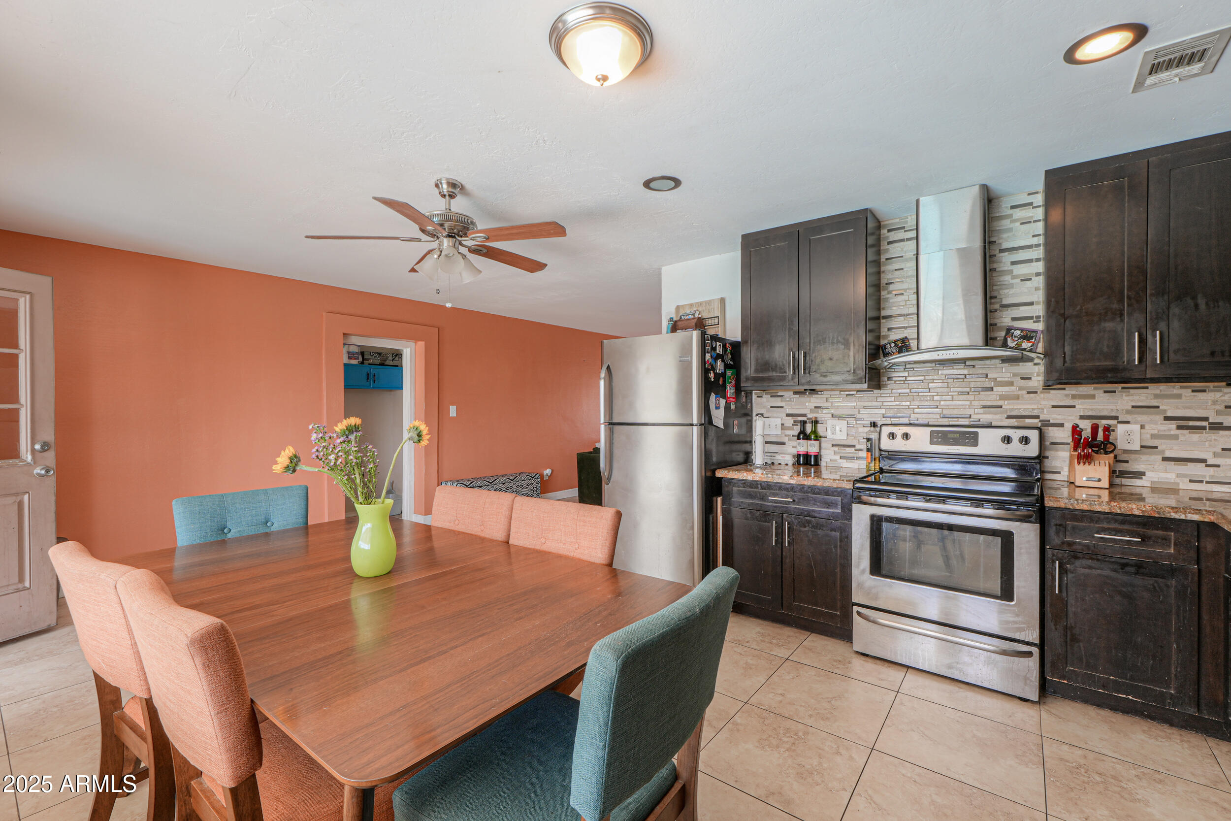 3413 West Ocotillo Road Phoenix, AZ 85017 - Photo 12 of 29 a kitchen with stainless steel appliances granite countertop a sink a stove a dining table and chairs