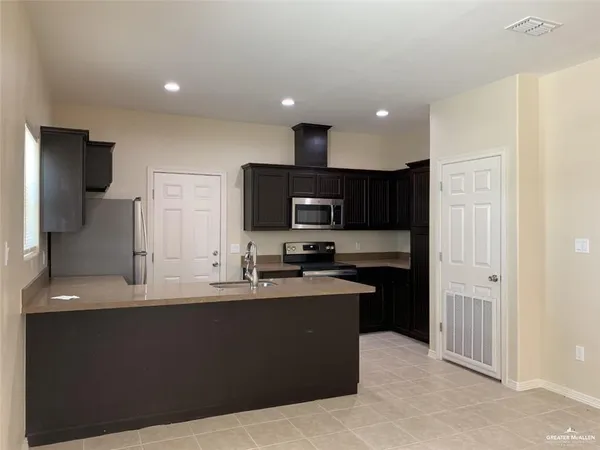 a kitchen with stainless steel appliances granite countertop a sink a stove and a refrigerator