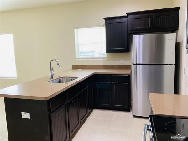 a kitchen with a sink a refrigerator a cabinets and a stove