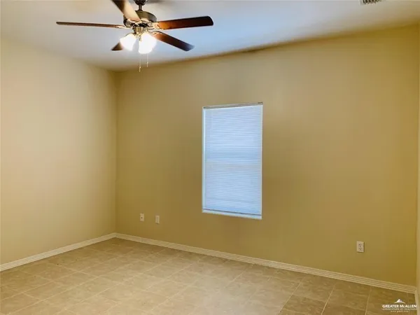 an empty room with a window and a fan