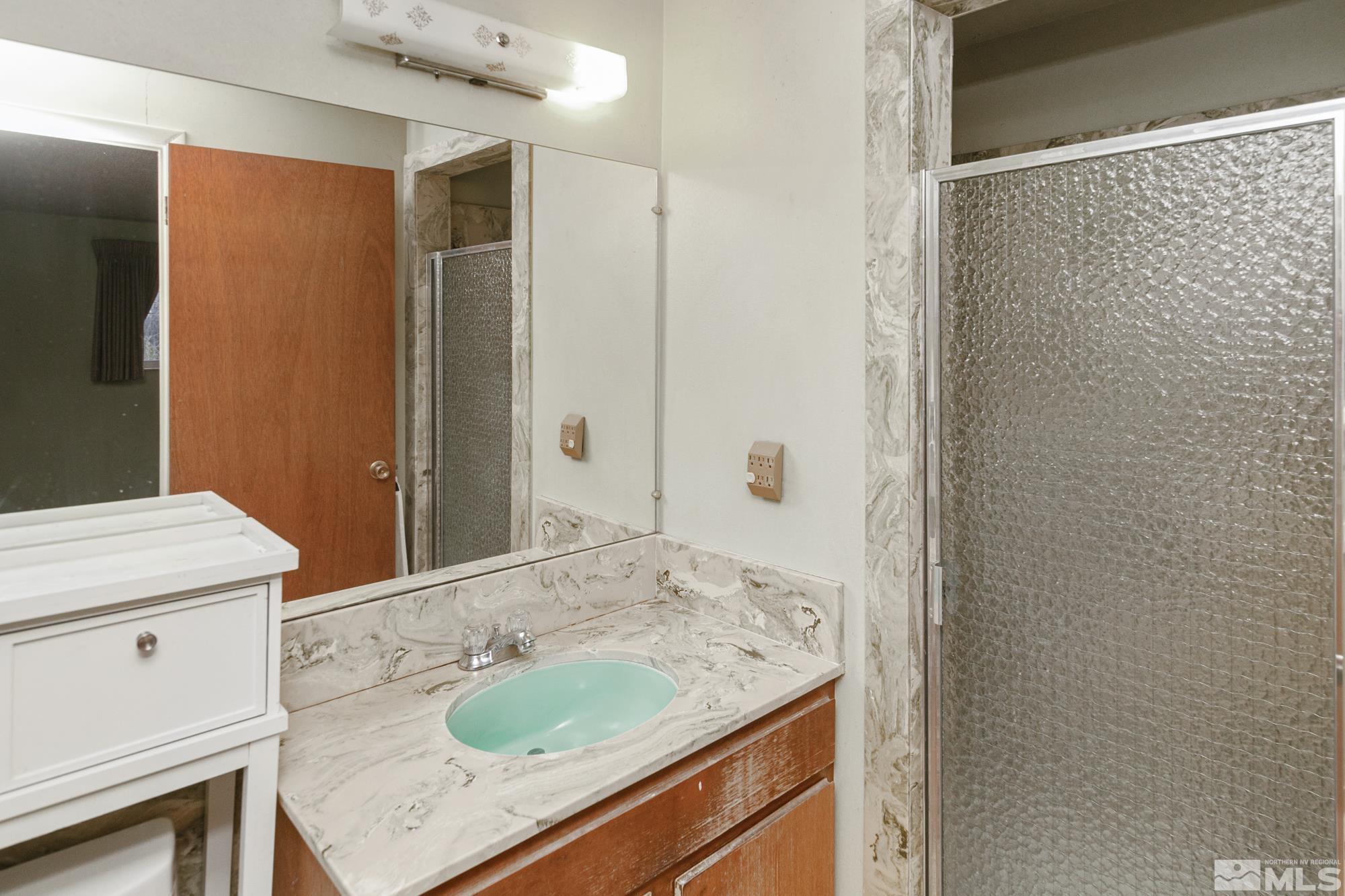 2300 Balsam Street Reno, NV 89509 - Photo 29 of 40 a bathroom with a granite countertop sink and a mirror