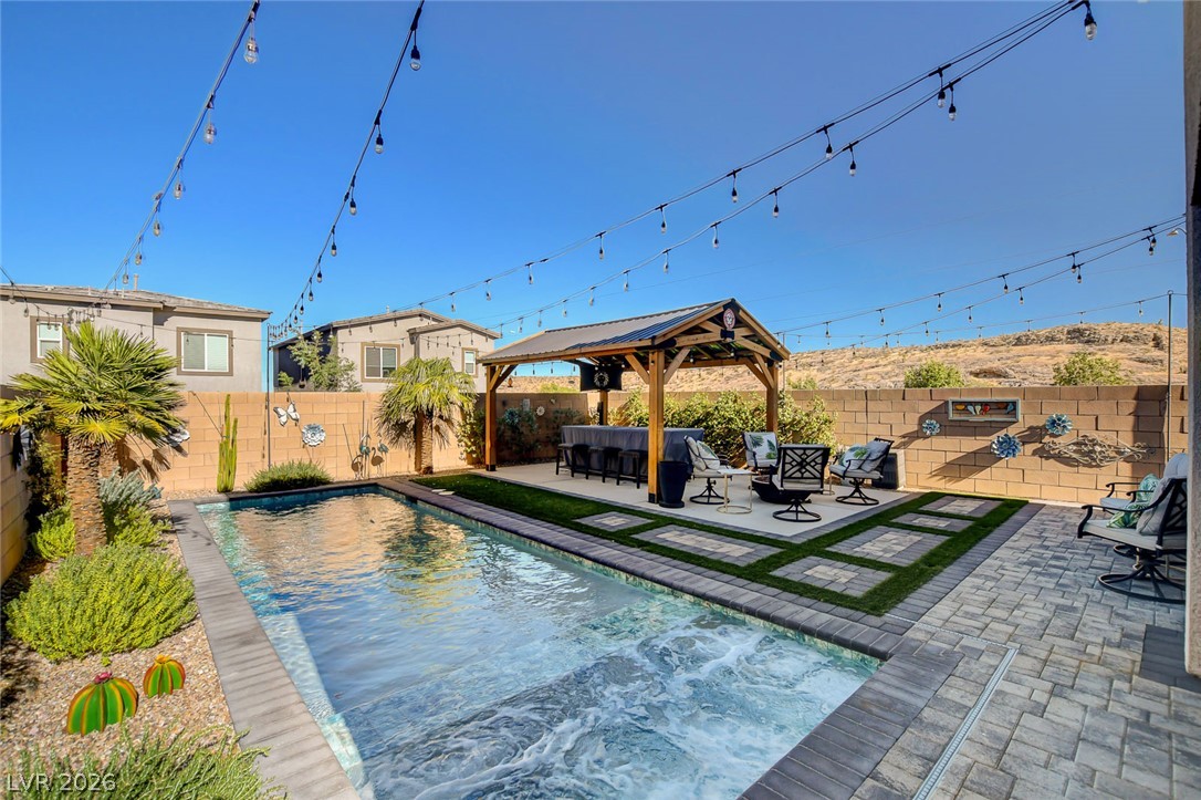 9688 Rankin Rdg Court Las Vegas, NV 89178 - Photo 45 of 53 An inviting backyard oasis offers a sparkling pool and a covered outdoor bar, perfect for entertaining under the open sky.