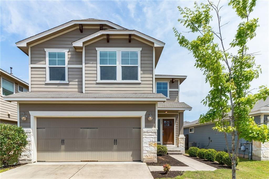 This property features an inviting exterior with horizontal siding, stone accents, and a prominent front-facing garage