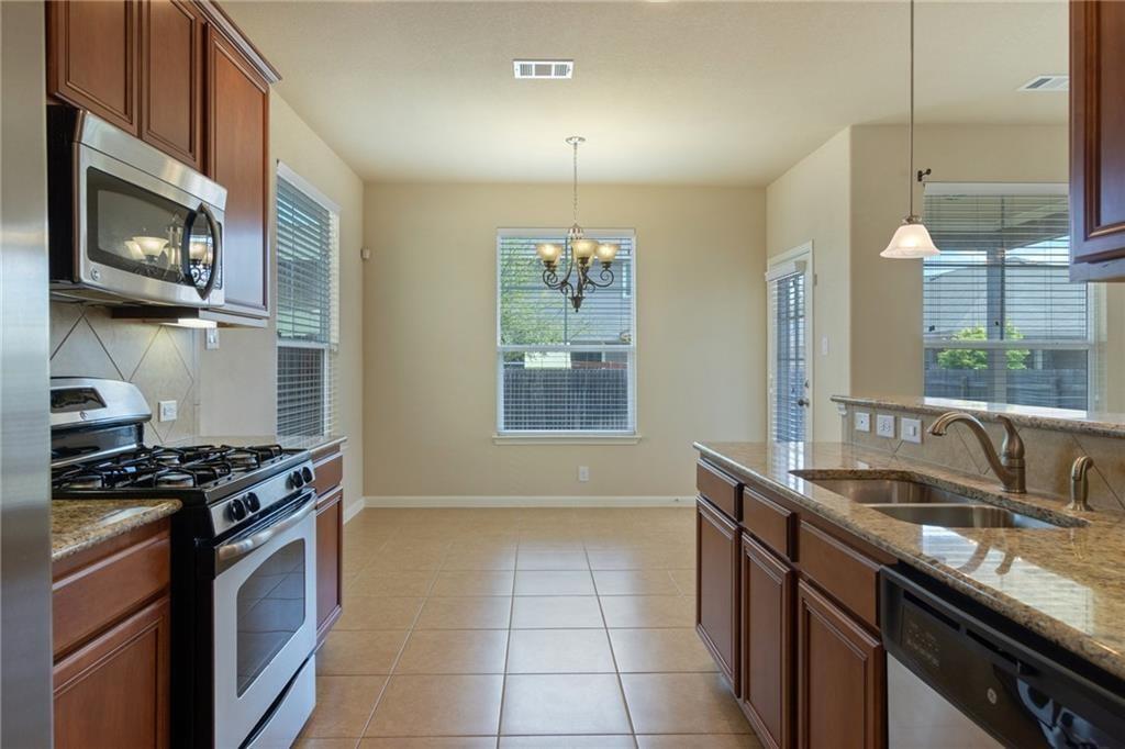 8505 Inca Dove Drive Austin, TX 78729 - Photo 11 of 30 The kitchen features granite countertops, stainless steel appliances, and wood cabinetry