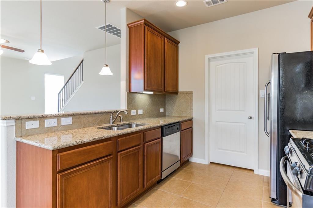 8505 Inca Dove Drive Austin, TX 78729 - Photo 13 of 30 The kitchen features granite countertops, wood cabinetry, stainless steel sink, and a dishwasher