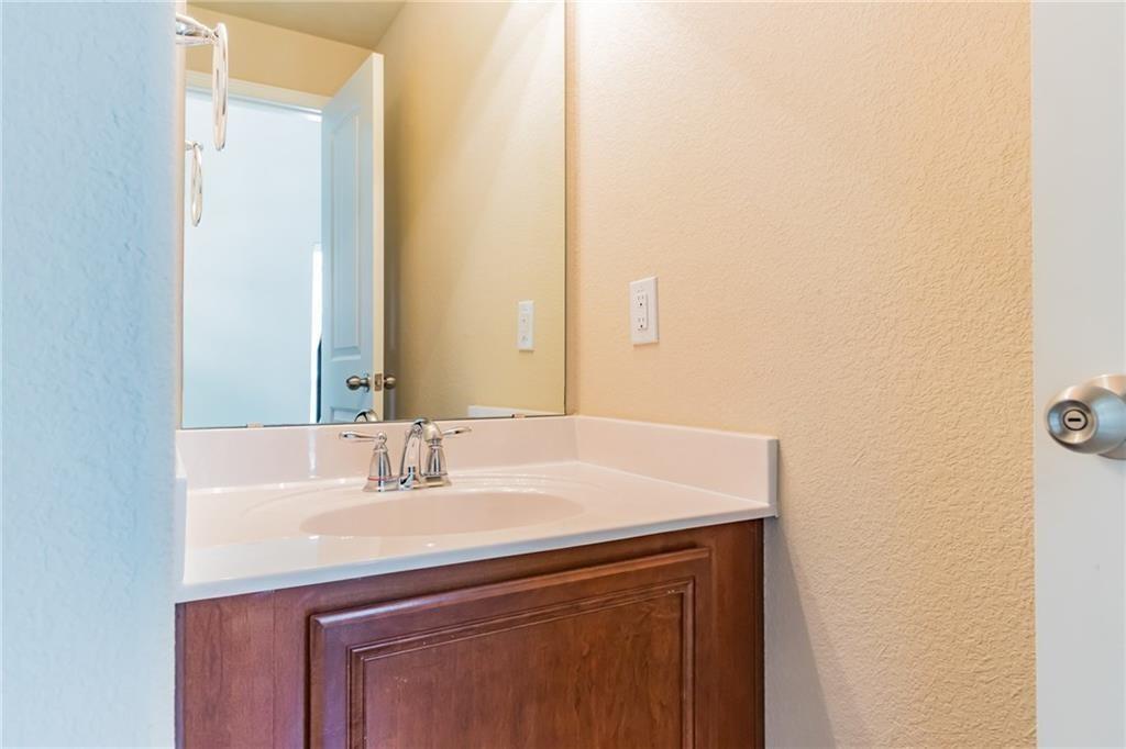 8505 Inca Dove Drive Austin, TX 78729 - Photo 14 of 30 Bathroom vanity with an integrated sink, a chrome faucet, and a large mirror