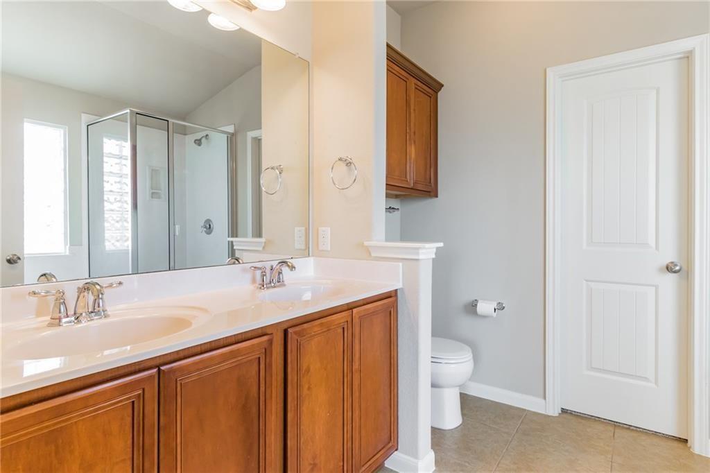 8505 Inca Dove Drive Austin, TX 78729 - Photo 19 of 30 The bathroom features a dual vanity with light-colored countertops and wood cabinetry
