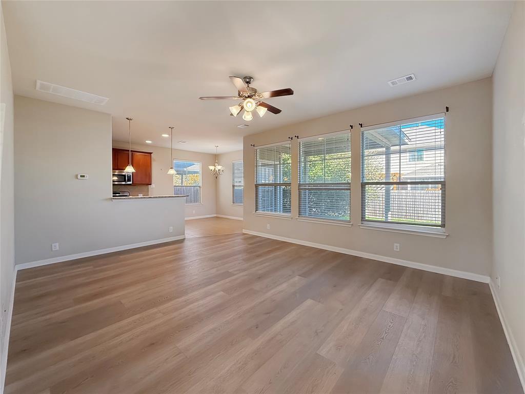 8505 Inca Dove Drive Austin, TX 78729 - Photo 7 of 30 Open concept living area with light-toned flooring, featuring a ceiling fan with integrated lighting