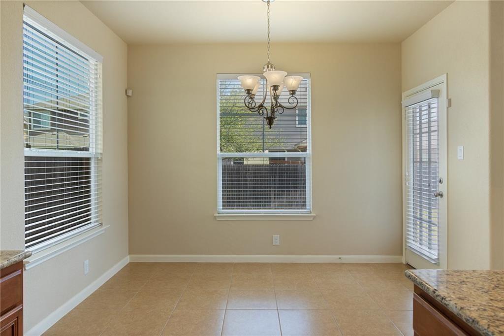 8505 Inca Dove Drive Austin, TX 78729 - Photo 10 of 30 Bright dining area featuring tile flooring, a decorative chandelier, and natural light from a window and glass paneled door