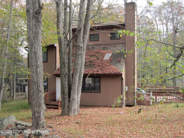 a view of a small house with a tree in the background