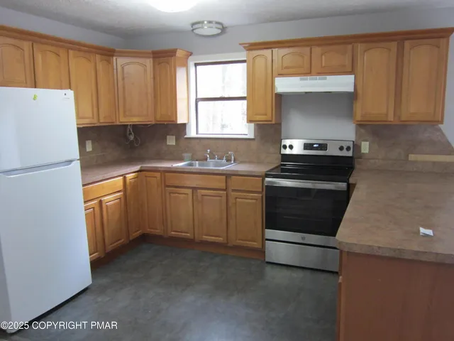 a kitchen with a sink stove and refrigerator