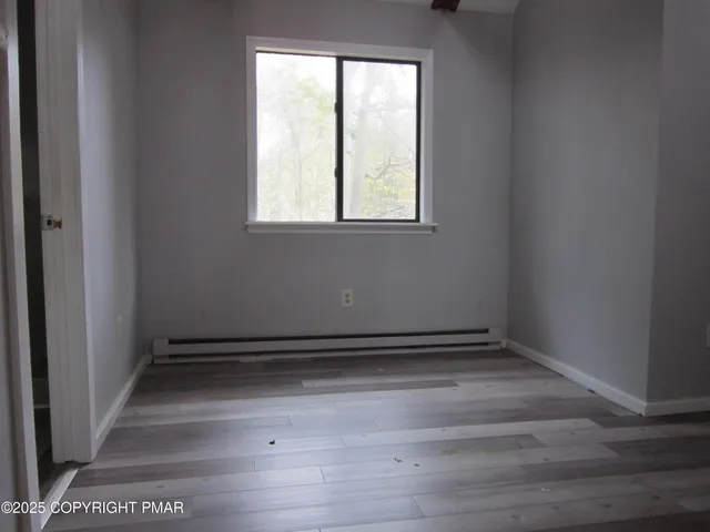 a view of a room with wooden floor and window
