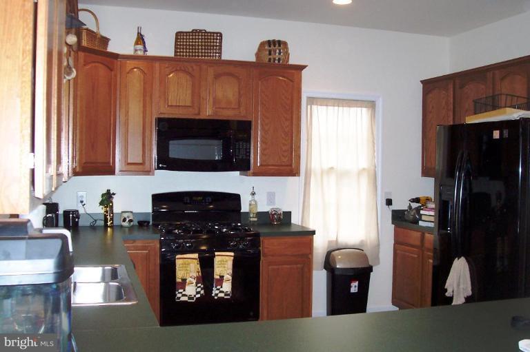 277 Freezeland Loop Road Linden, VA 22642 - Photo 3 of 10 a kitchen with granite countertop a refrigerator stove and wooden floor