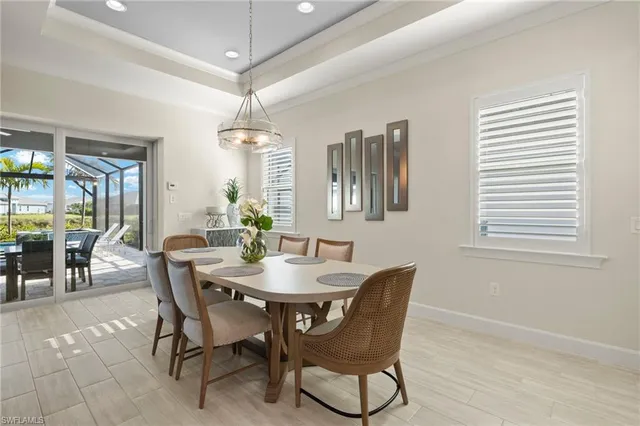 a dining room with furniture a chandelier and window