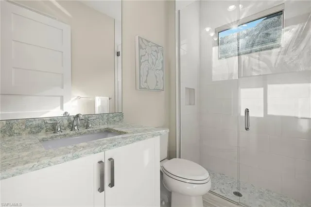 a bathroom with a granite countertop sink toilet and shower