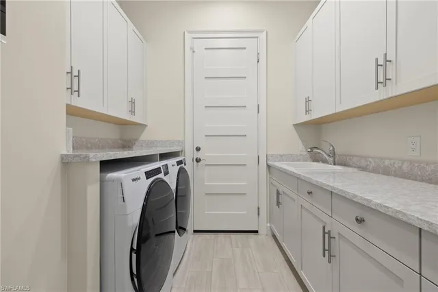 a utility room with cabinets washer and dryer
