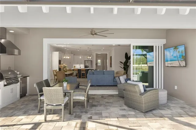 a living room with couches and kitchen view with wooden floor