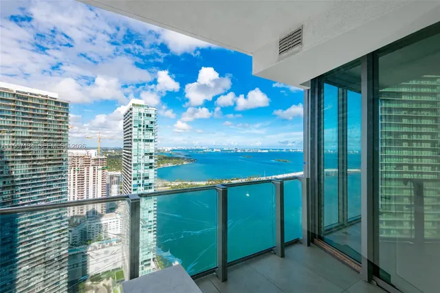 a living room with furniture potted plant and a large window