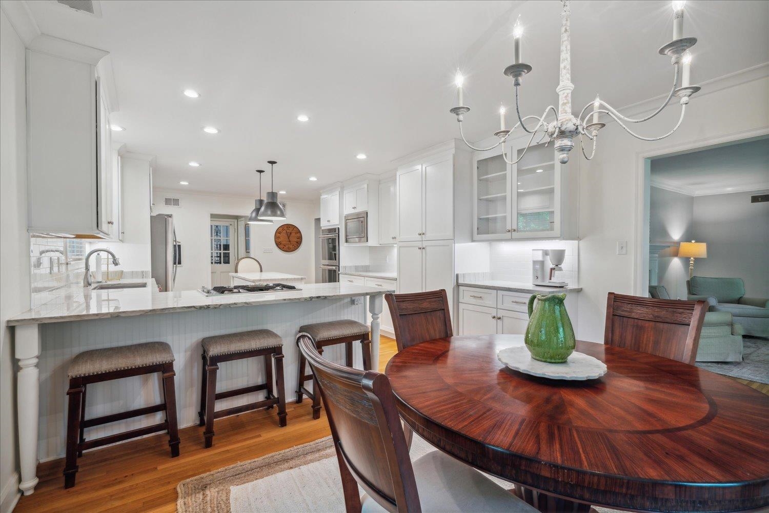 1141 Fair Meadow Road Memphis, TN 38117 - Photo 13 of 40 Dining room with crown molding, sink, light hardwood / wood-style flooring, and a notable chandelier