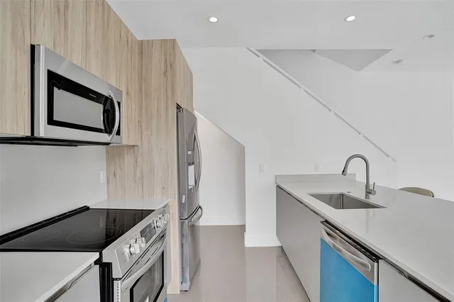 a kitchen with stainless steel appliances granite countertop a sink and a microwave